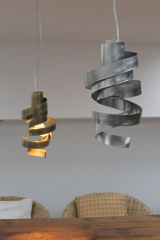 Hanglampen design. Rvs hanglamp en moderne lampen boven de tafel, in een hal, serre of eetkamer. Staal en messing hanglamp design.
